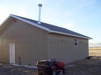 Wide view standing NW of the shop, looking SE.  The vent for the 200k BTU heater is visible, the two motion lights to the West, 