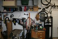 Closeup of North wall.  Drill press, small wood working bench, hydraulic press with porta-power behind it.   Overhead shelf with