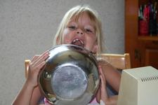 Carrie helps make brownies by licking the bowl