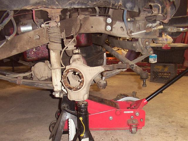 To loosen the lower nut, place pressure on the balljoint
