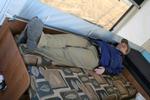 Tom tries out the convertible couch - made into a bed - still short (head on the other bed)